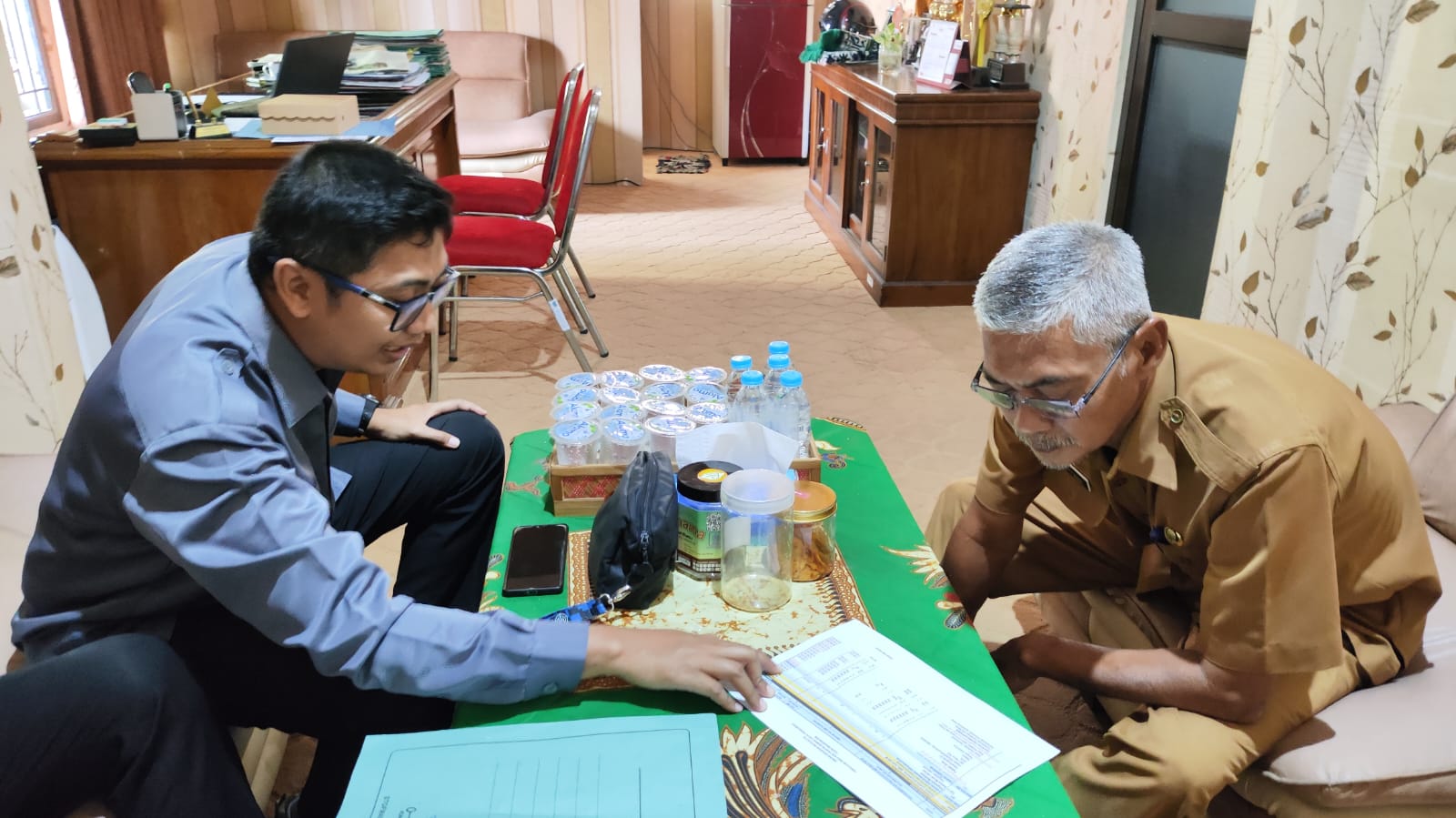 Johan Menunjukkan Rencana Anggaran Belanja (RAB) kepada Sonhadji dalam Kunjungannya di Kantor Bakesbangpol pada Selasa (29/7) siang